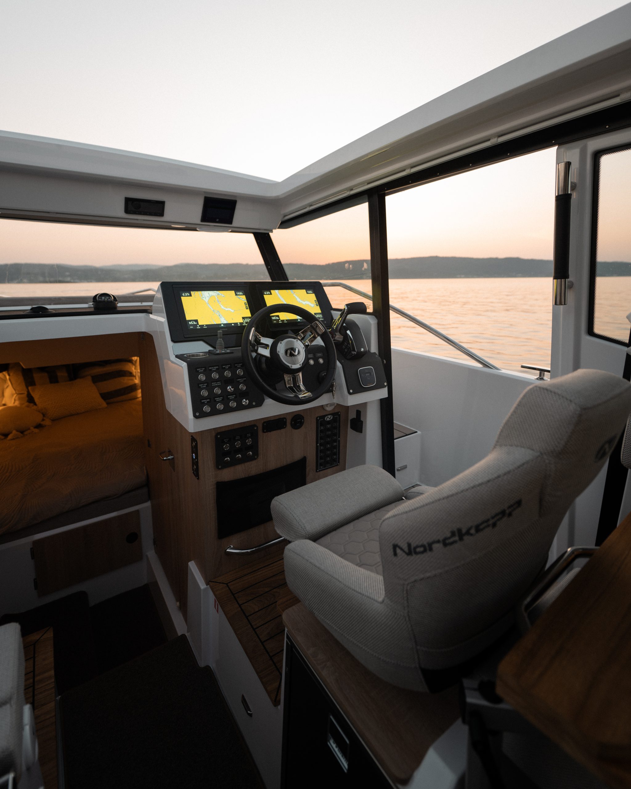 Nordkapp Coupe 830 zárt kabinos túrahajó prémium kormányállása és kényelmes kabinja naplementében - BFL Boats